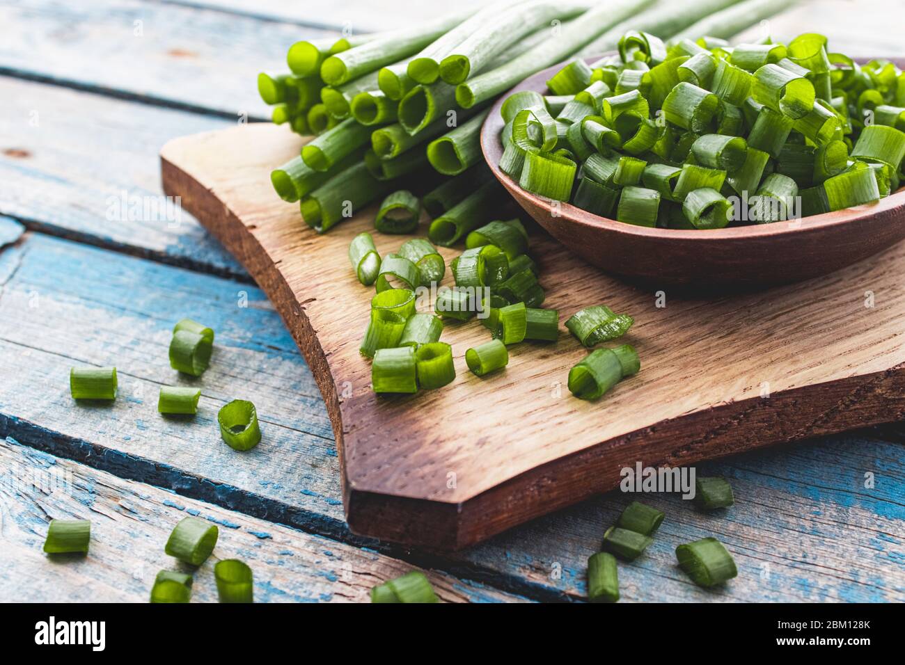 Fresh green onion chopped and lies on a bowl on a chopping board on a ...