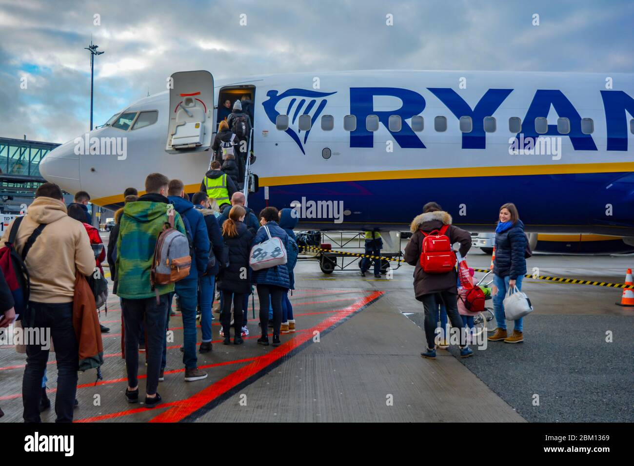 Riga Airport RIX, Latvia 01/30/20: Ryanair airplane with a long line of passengers patiently ready to embark.Logo of the irish low cost airliner,crowd Stock Photo