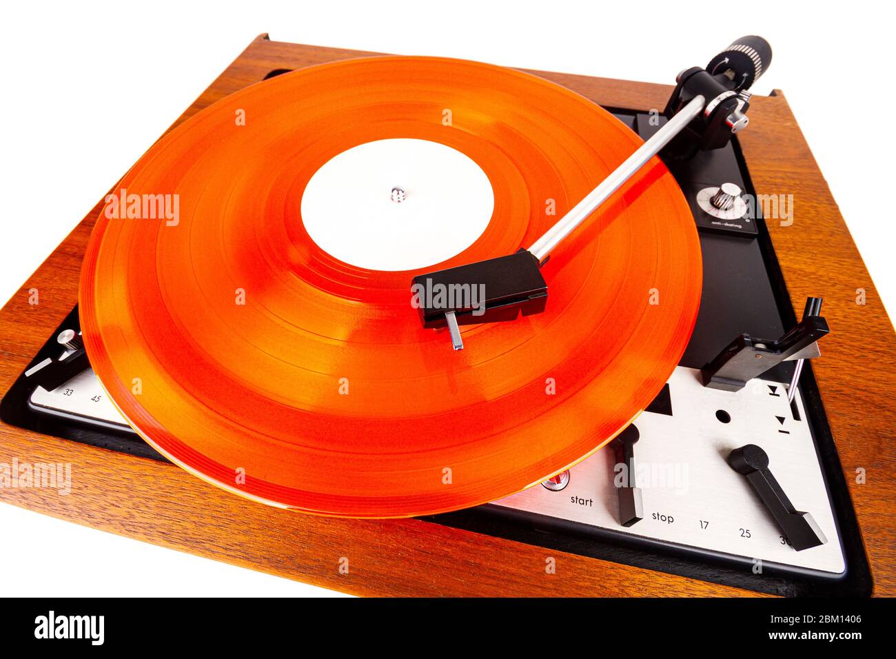 Vintage turntable with a red vinyl isolated on white. Wooden plinth