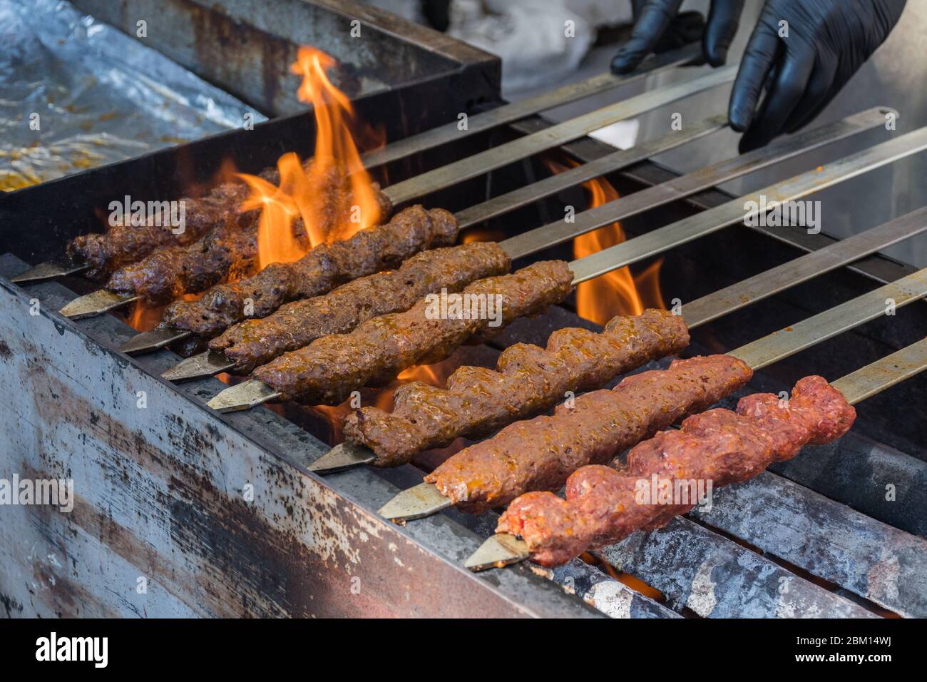 Adana kebab (ground lamb minced meat on skewer on grill over charcoal).Chef  preparing traditional authentic Turkish shaworma. Middle eastern cuisine  Stock Photo - Alamy