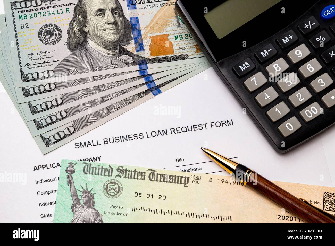 Small business loan form, 100 dollar bills. Concept of financial assistance, stimulus payment and recession during Covid-19 coronavirus pandemic Stock Photo