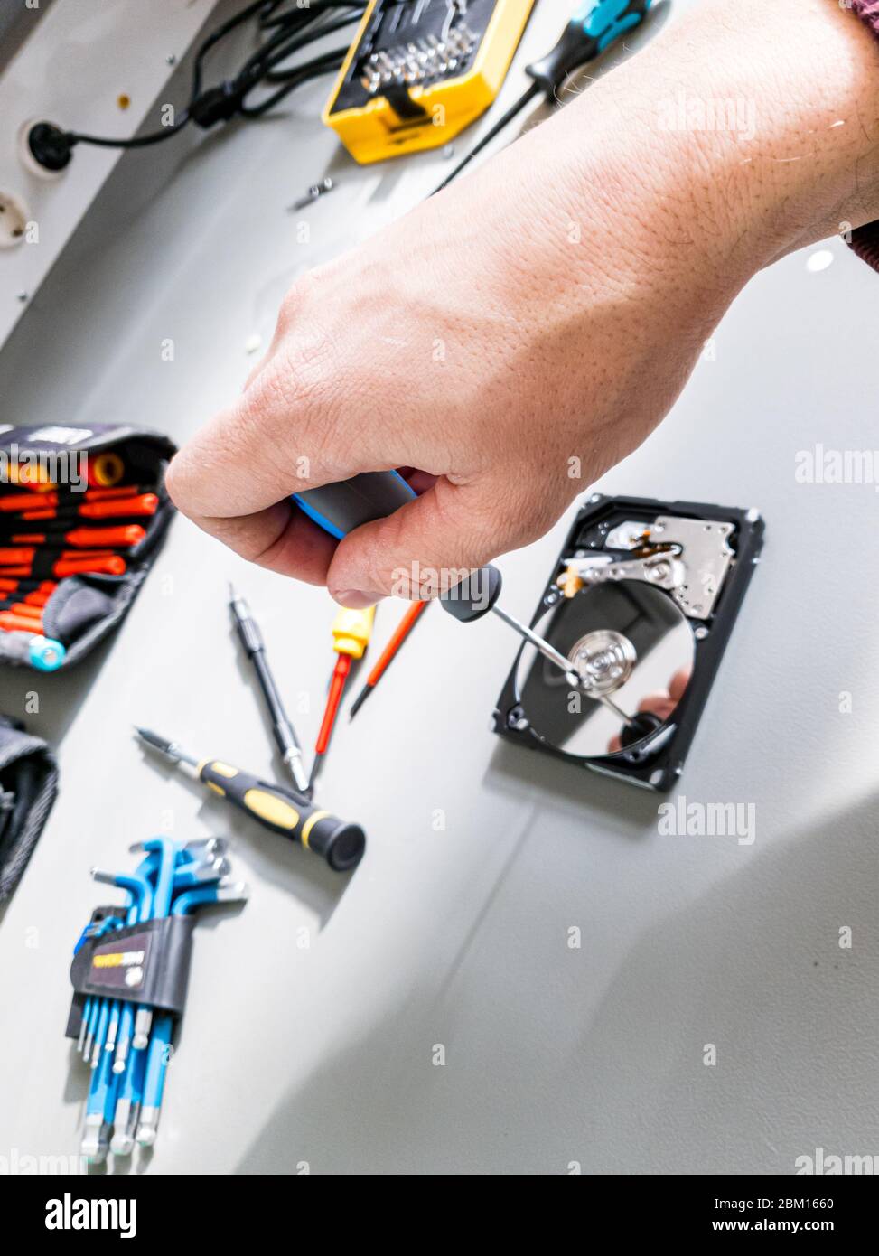 Repairing malfunctioned computer hard drive removing screws and