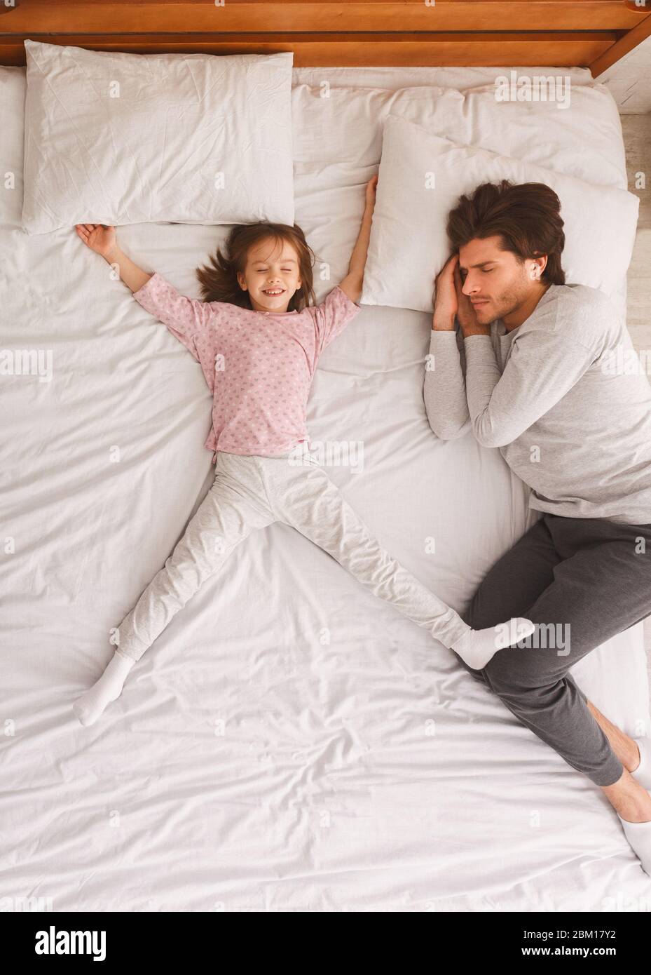 Father and little daughter sleeping together on bed Stock Photo - Alamy