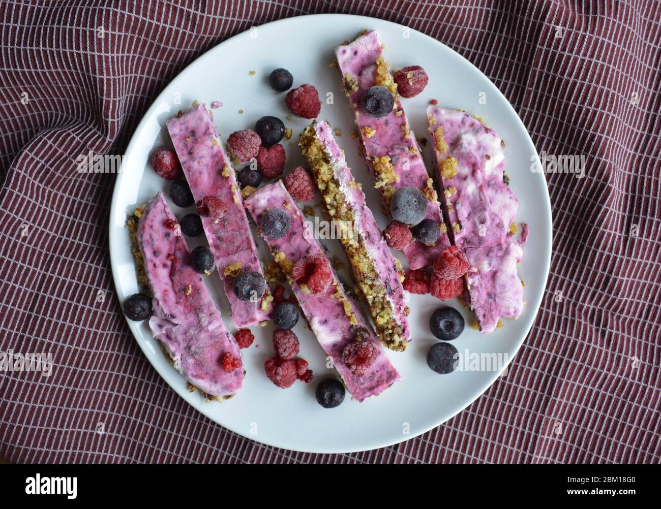 Homemade pink frozen yoghurt bars with raspberries and blueberries