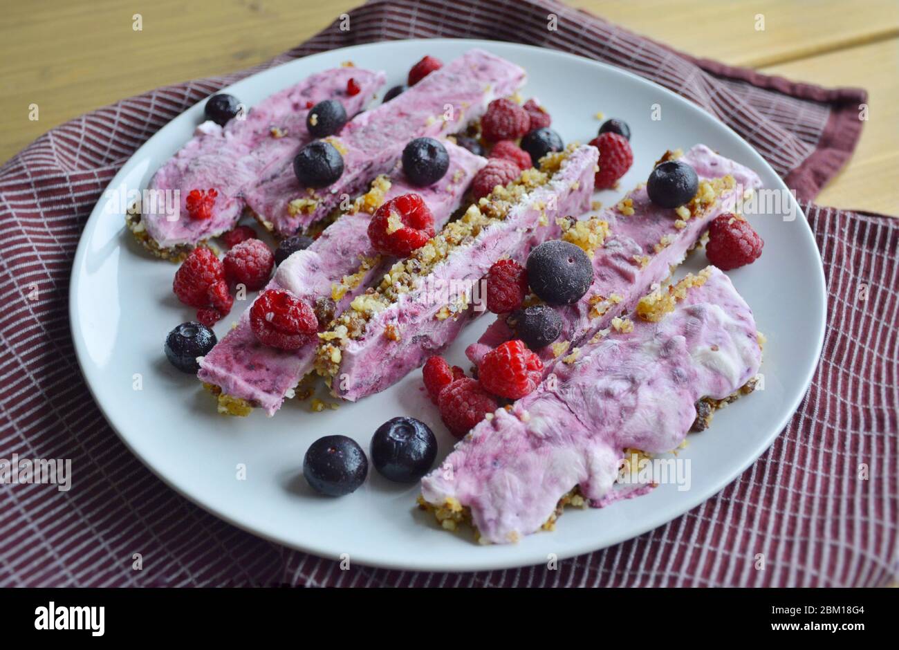 Homemade pink frozen yoghurt bars with raspberries and blueberries. Snack for the summer days Stock Photo