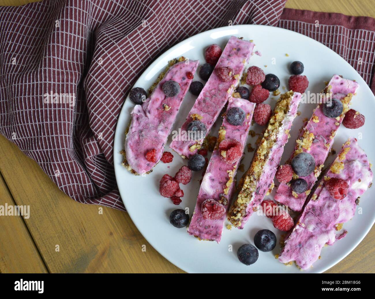 Homemade pink frozen yoghurt bars with raspberries and blueberries. Snack for the summer days Stock Photo