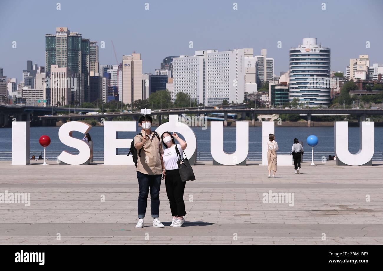 Seoul, South Korea. 6th May, 2020. People take selfies at Yeouido Hangang Park in Seoul, South Korea, May 6, 2020. South Korea on Wednesday began a so-called 'distancing-in-daily-life' campaign to bring people closer to a normal life. The campaign allows people to resume socio-economic activities on the condition of keeping in place the eased quarantine rules, such as wearing masks, standing at least a meter away from each other, washing hands frequently and coughing with mouth covered by sleeves. Credit: Wang Jingqiang/Xinhua/Alamy Live News Stock Photo