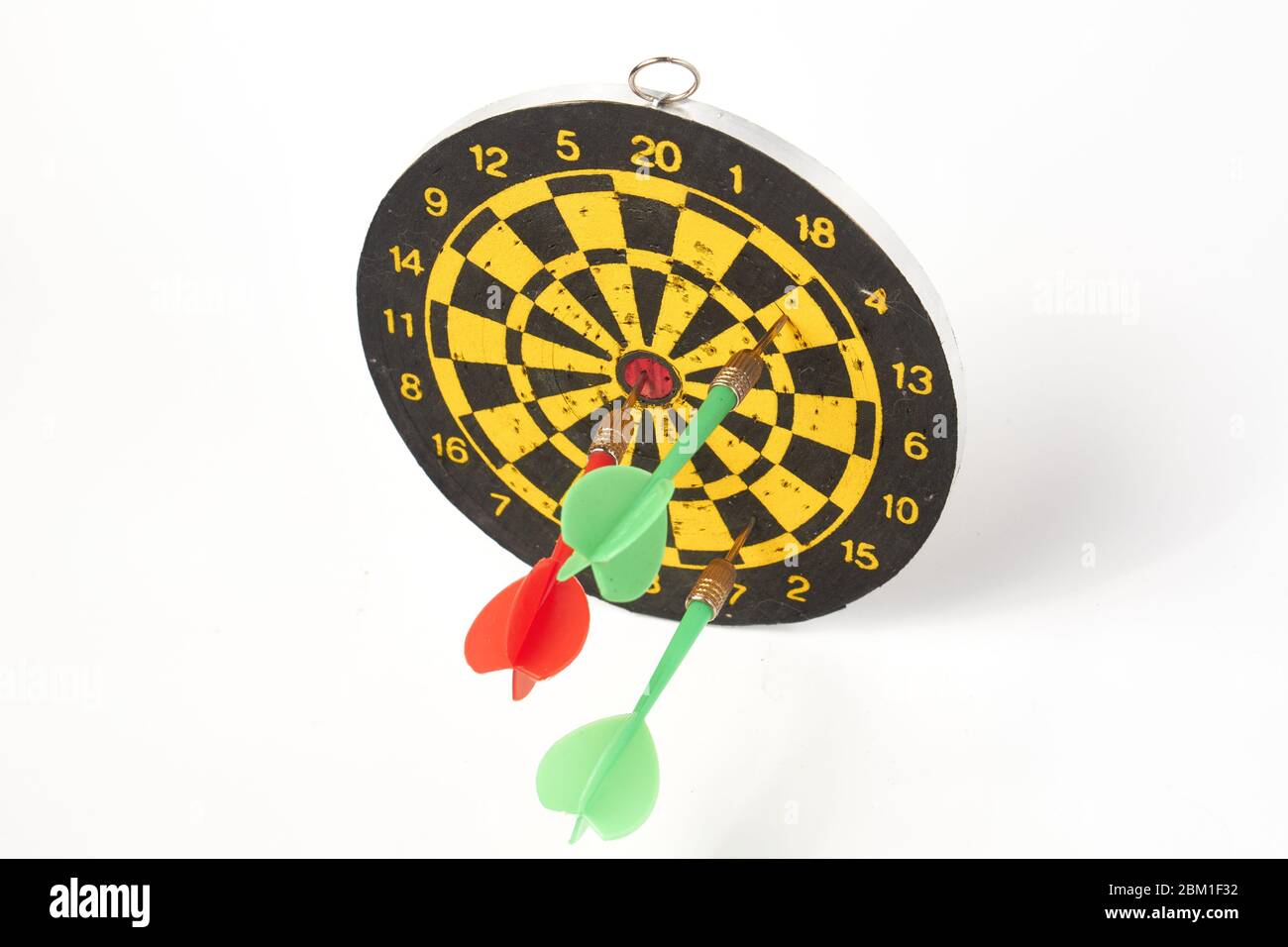 darts target darts all in holes with two green darts and one red on a