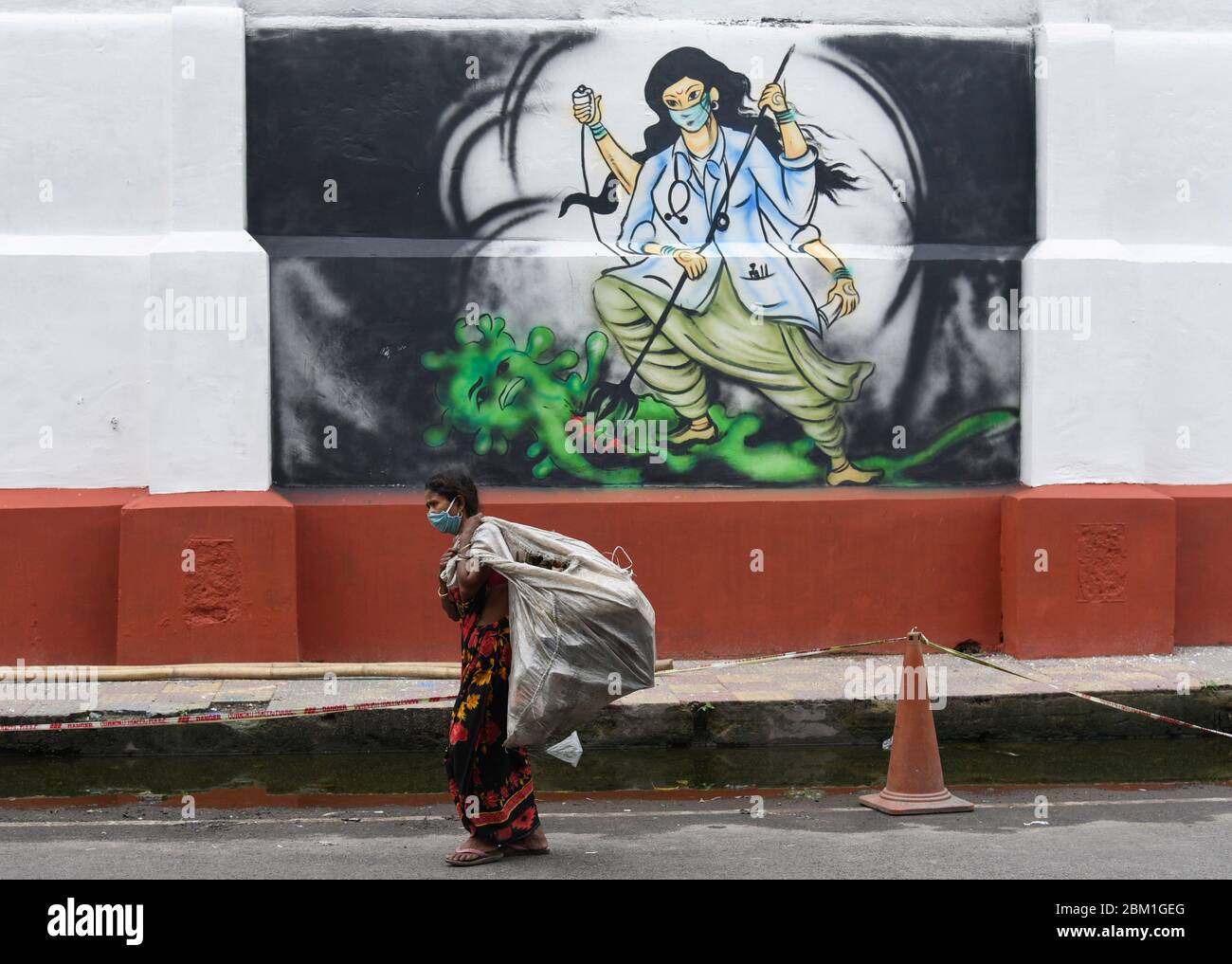 Guwahati, Assam, India. 6th May, 2020. Ragpicker walking past to a mural related to Coronavirus, authorities eased restrictions, during the ongoing COVID-19 nationwide lockdown, in Guwahati. Credit: David Talukdar/ZUMA Wire/Alamy Live News Stock Photo