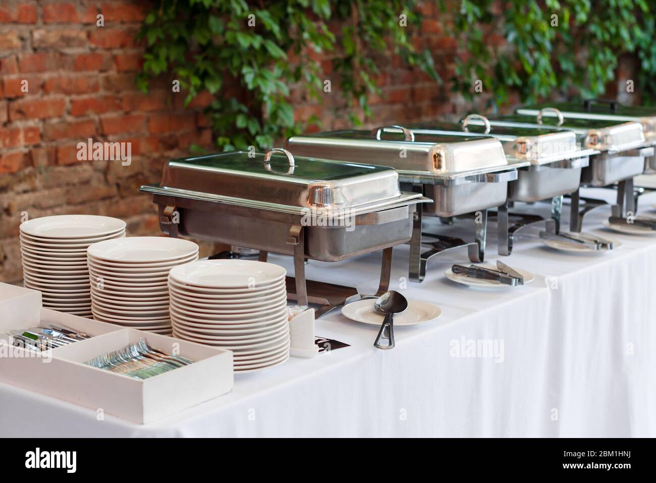 Buffet heated trays standing in line ready for service. Outdoors buffet