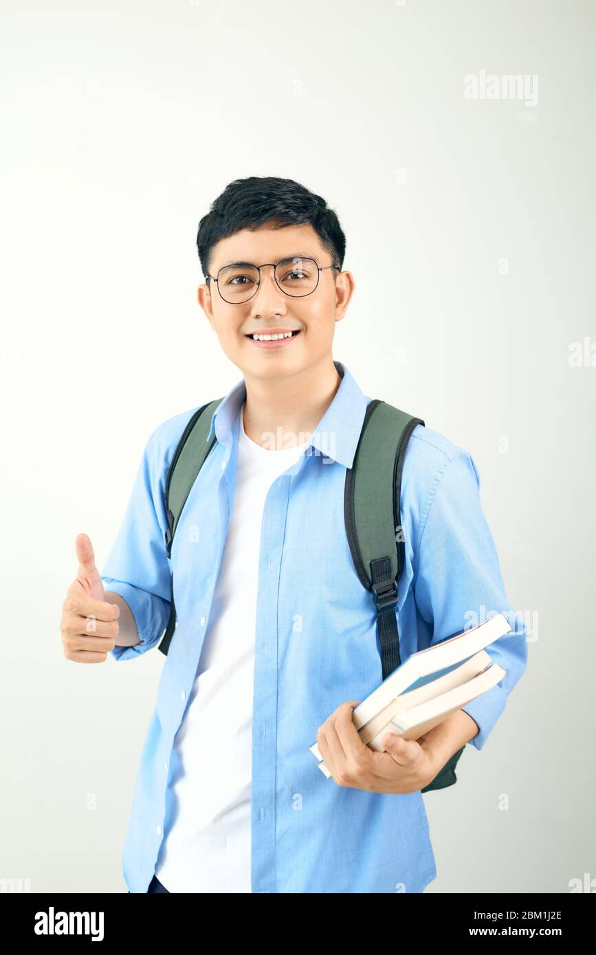 Portrait of a smiling male student with backpack showing thumbs up over ...