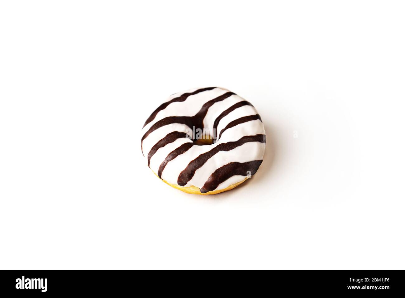 Glazed striped donut on white background, isolated. Party food concept with copy space. Top view. Stock Photo