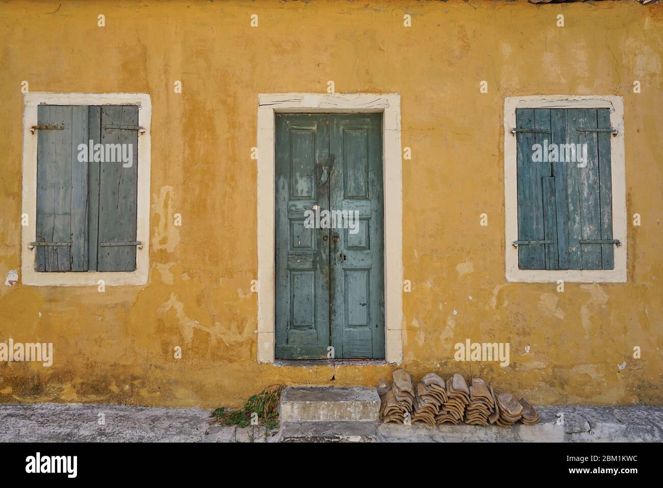 Exteriror of traditional abandoned village house with windows and door in Assos, Kefalonia Island, Ionian Sea, Mediterranean, Greece Stock Photo