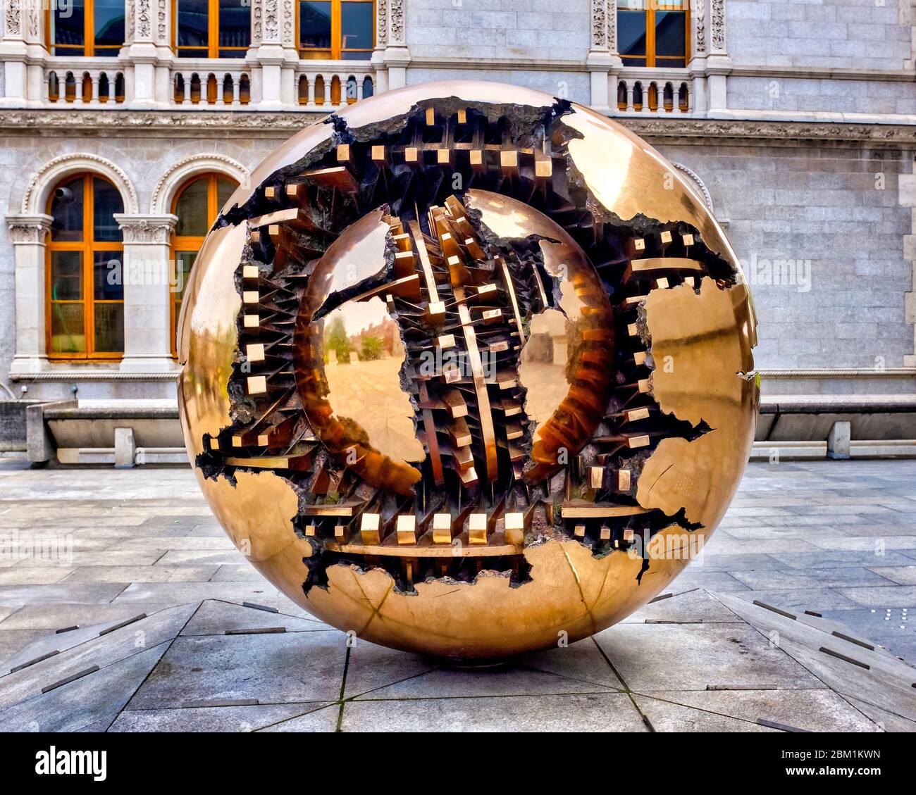 Arnaldo Pomodoro's Sphere Within Sphere sculpture stands outside the Berkeley Library of the Trinity College, Dublin, Ireland Stock Photo