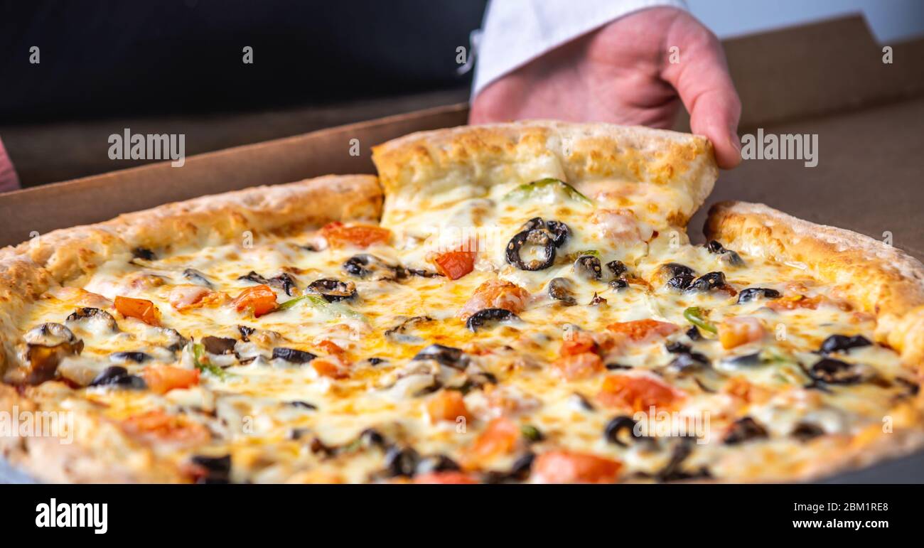 A slice of fresh hot vegetarian pizza with a stretch of mozzarella