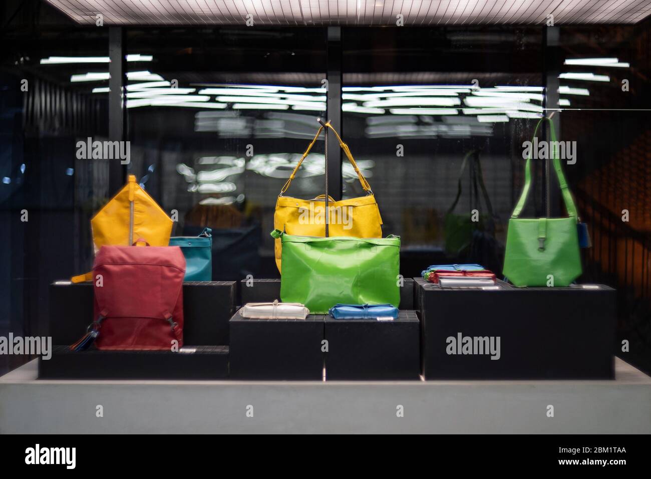SHANGHAI, CHINA - NOVEMBER 28, 2018. Retro film photo with blurred background. Fashionable colourful bags made from recycled materials are displayed i Stock Photo
