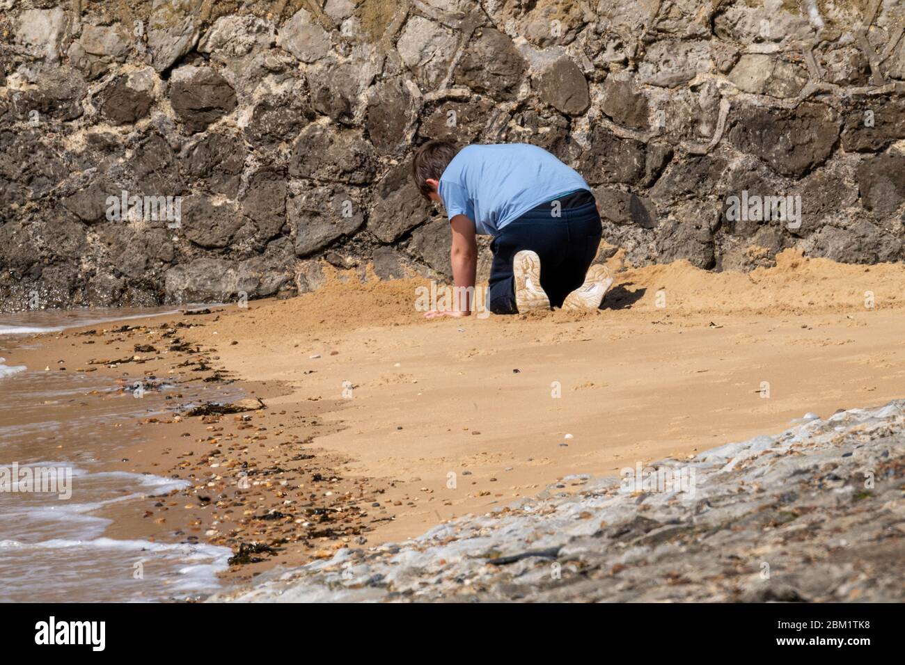 Southend on Sea, Essex, UK. 6th May, 2019. Covid-19 lockdown seafront, Southend on Sea, Essex, solitary boy builds sandcastle, Credit: Ian Davidson/Alamy Live News Stock Photo