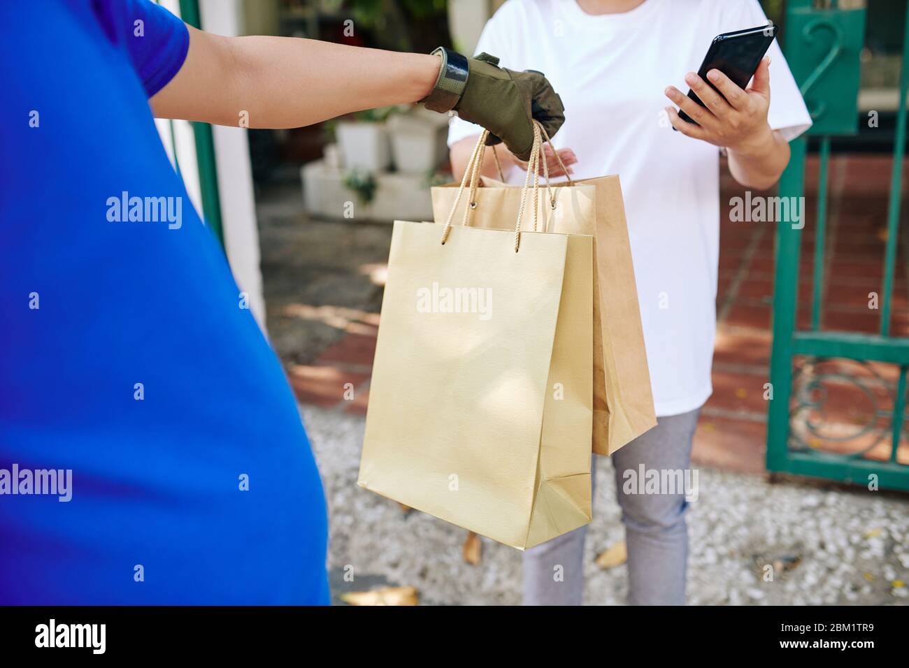 Delivery man giving paperbags to female customer who is leaving tips