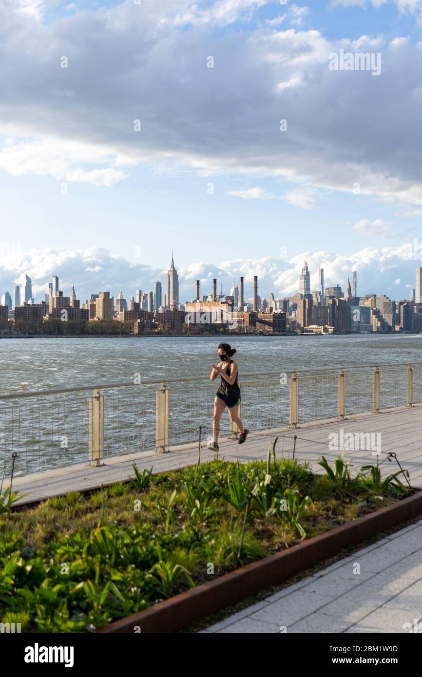 Williamsburg, New York, USA - May 3 2020: Domino Park with Manhattan view with People and Joggers Stock Photo