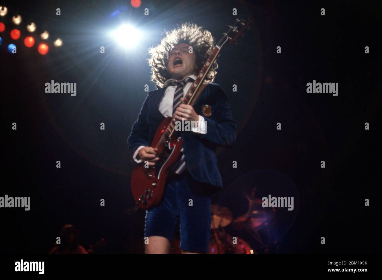DETROIT - NOVEMBER 17: Angus Young, lead guitarist for AC/DC, wearing his iconic British schoolboy uniform and playing his red Gibson SG, performs during the Flick of the Switch/Monsters of Rock tour, on November 17, 1983, in Detroit, Michigan. (Photo by Ross Marino/Rock Negatives) Stock Photo