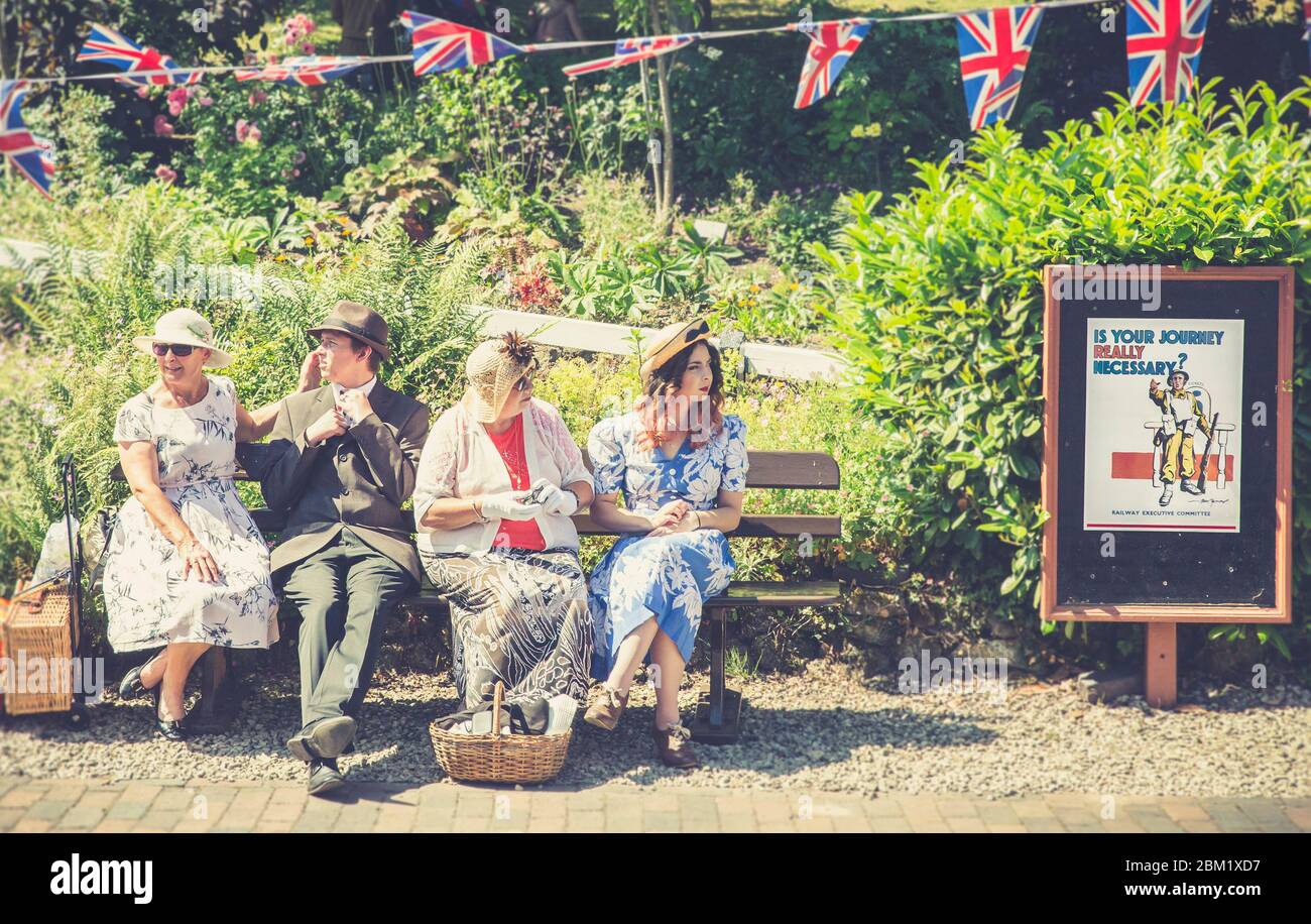 Retro vintage view of re-enactors in 1940s dress, Arley vintage train station, Severn Valley Railway 1940s WWII wartime summer event, UK. Vintage sign. Stock Photo