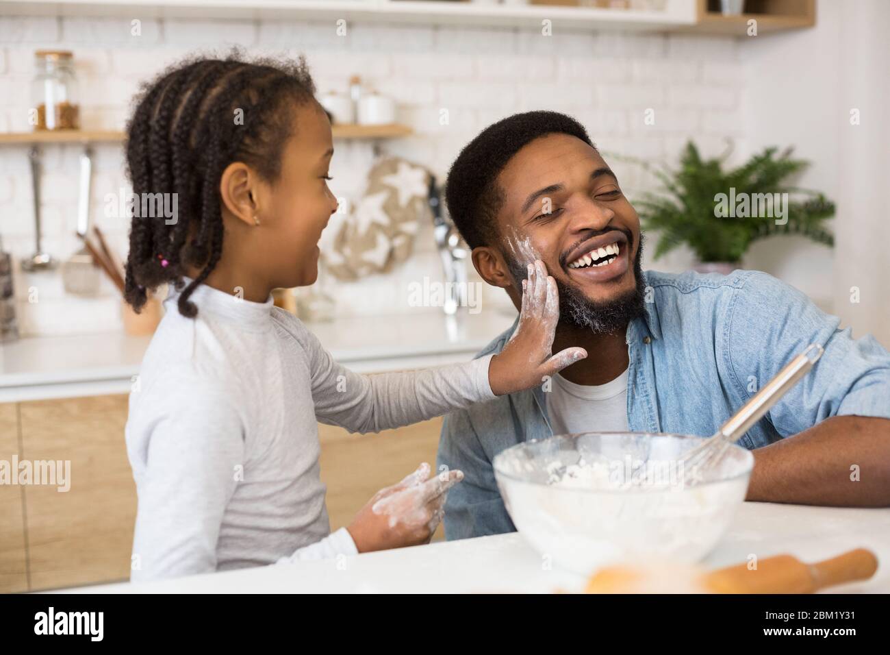 Cheerful father and daughter having fun while cooking Stock Photo