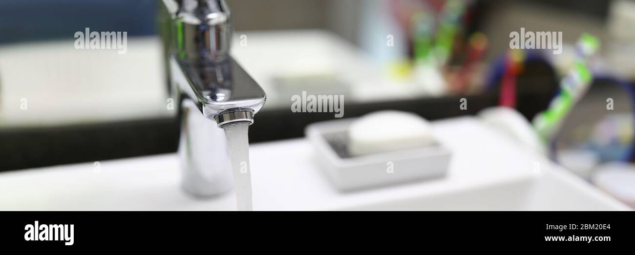 Stream water flows from faucet into bathroom sink Stock Photo Alamy