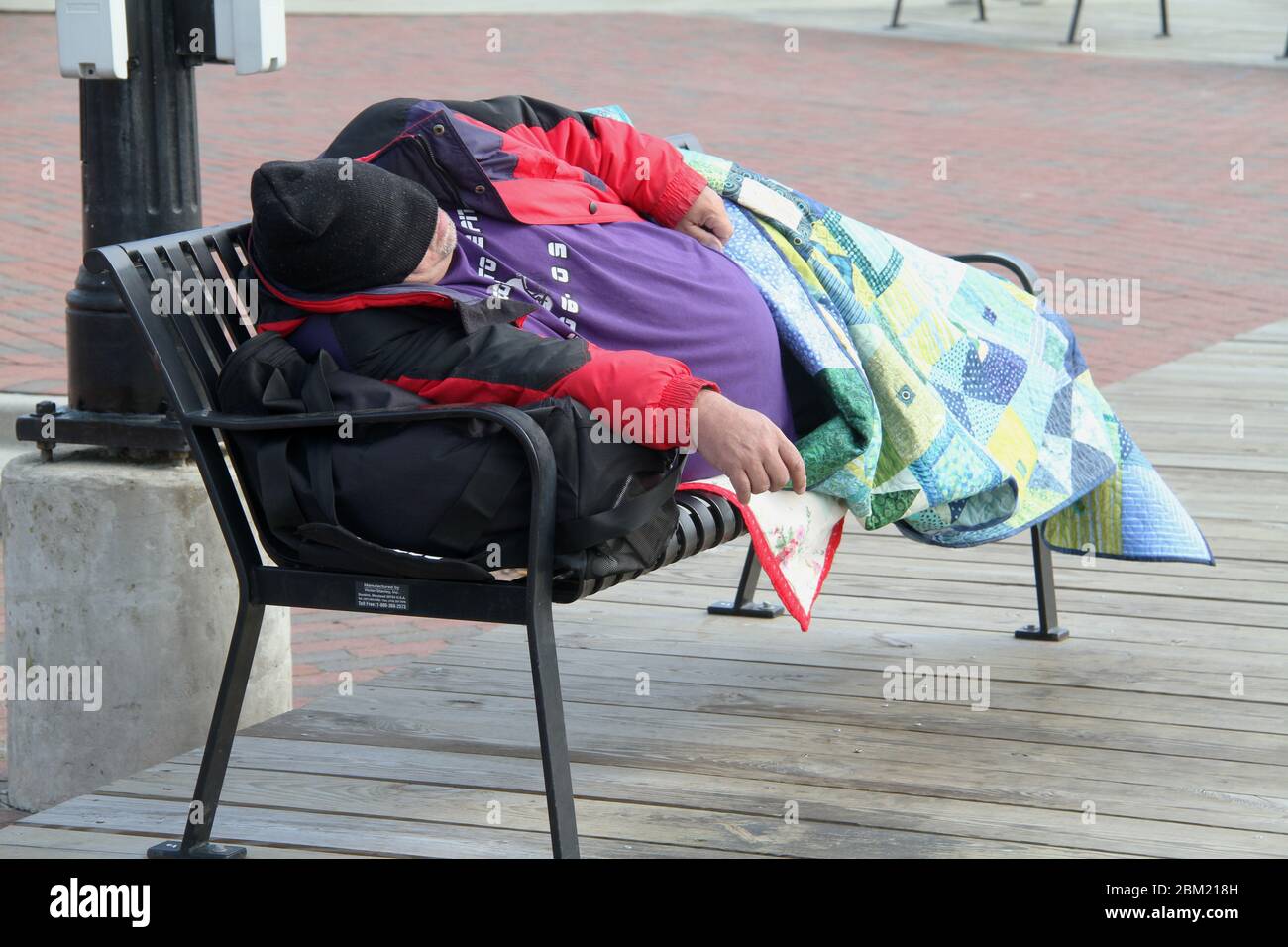 Homeless man sleeping on a public bench in the city Stock Photo - Alamy