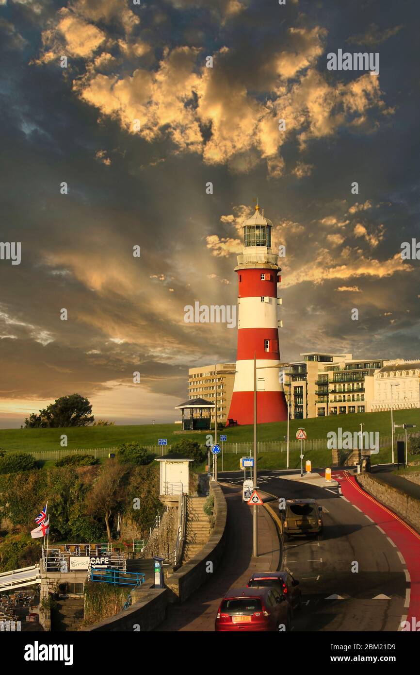 Sunrays breaking through the cloud at sunrise behind the lighthouse on Plymouth Hoe, Devon, UK Stock Photo