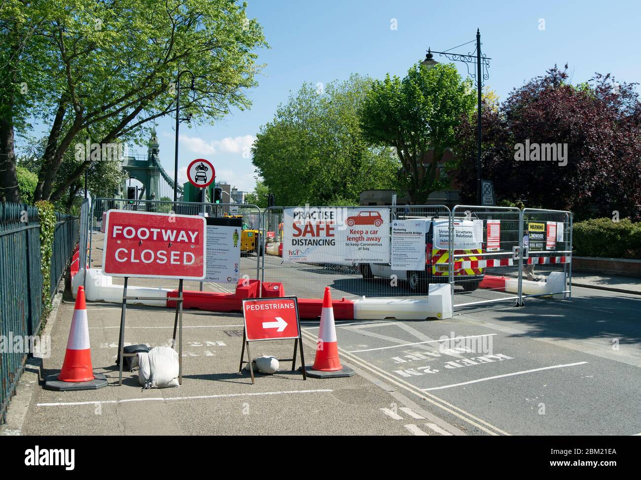 signs and banners indicating safe distancing, a closed footway and pedestrian route on the