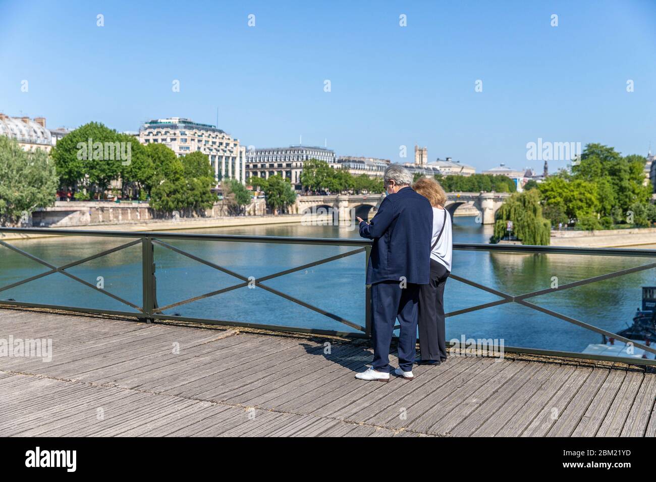 Two parisian crossing the Pont des arts in Paris during the lock down Coronavirus covid-19 Stock Photo