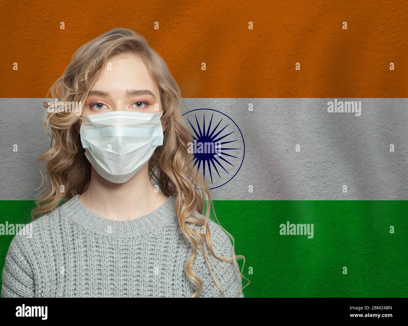 Young woman wearing a protective mask with national indian flag. Flu epidemic and virus protection concept Stock Photo