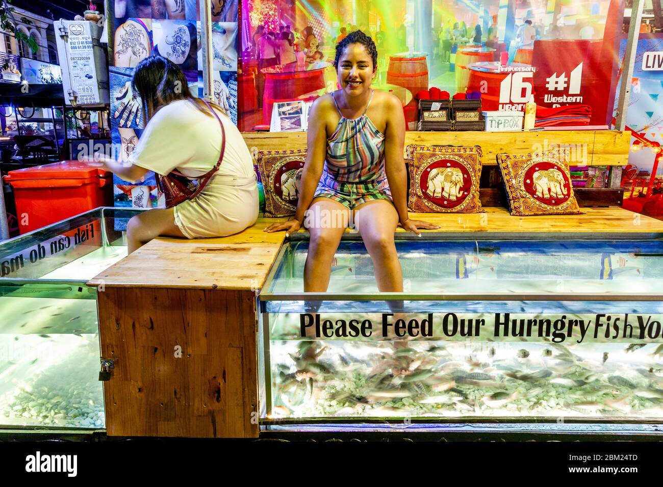 A Smiling Tourist Having A Fish Pedicure, Pub Street, Siem Reap, Cambodia. Stock Photo