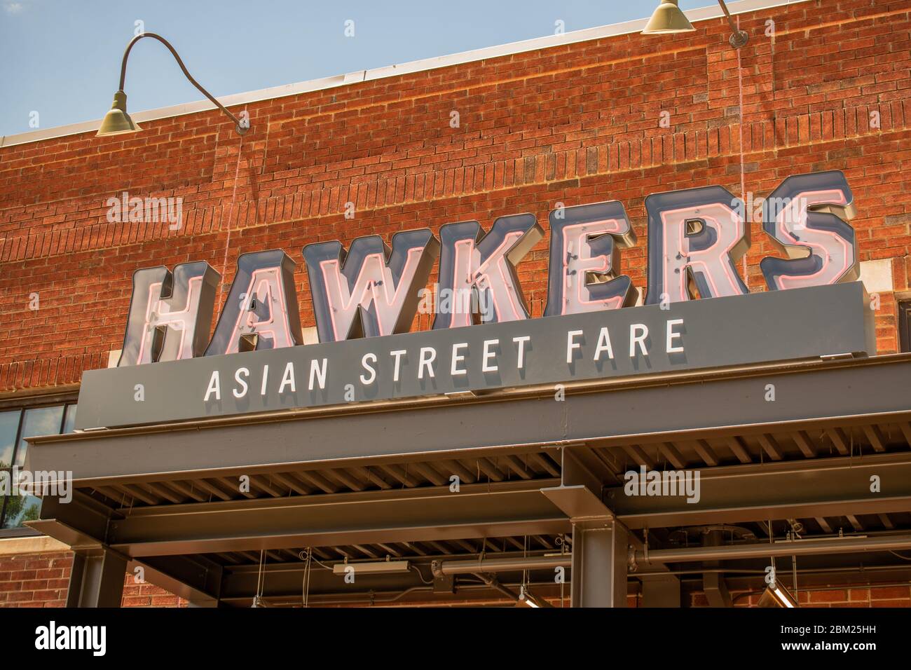 Charlotte, NC/USA - May 14, 2019: Horizontal medium closeup of 'Hawkers Asian Street Fare' South End restaurant brand signage of facade of building. Stock Photo