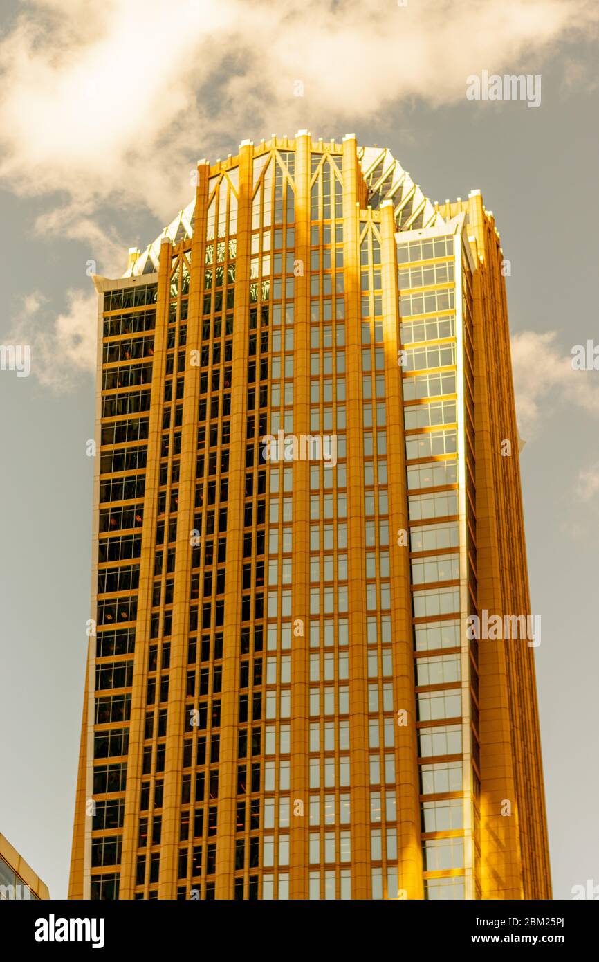 Charlotte, NC/USA - April 26, 2019:  Medium vertical shot of 'Hearst Tower' in uptown in a georgous golden light below luminescent clouds. Stock Photo