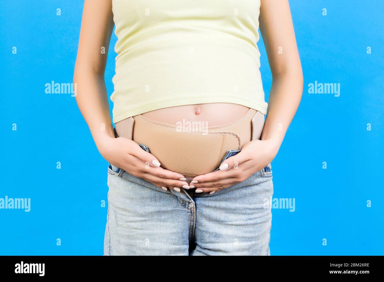 Close up of pregnant woman wearing pregnancy corset against backpain at  blue background with copy space. Orthopedic abdominal support belt concept  Stock Photo - Alamy