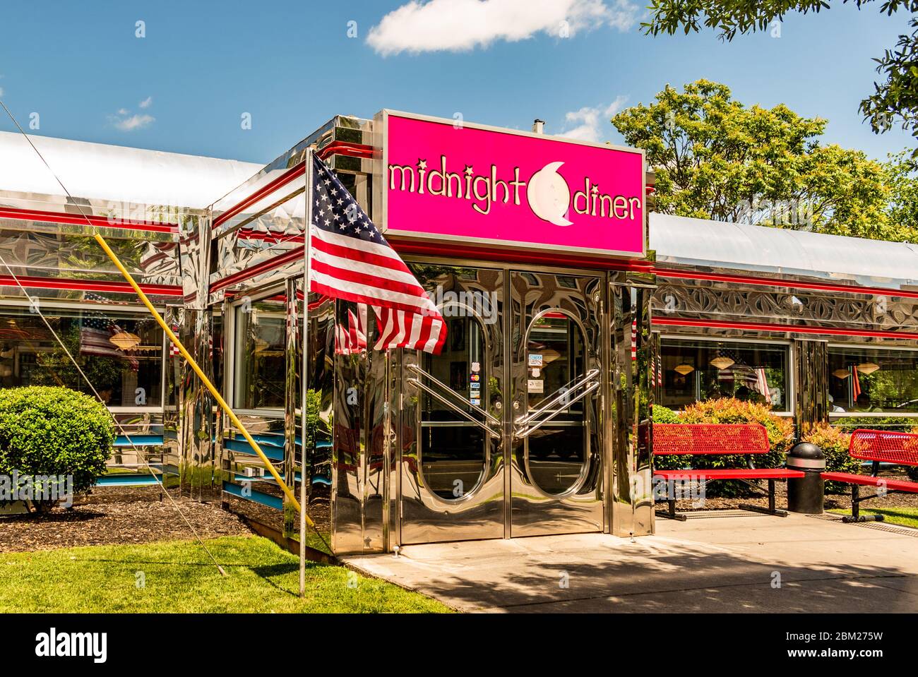 Charlotte, NC/USA - May 14, 2019: Horizontal medium shot of 'Midnight Diner' eatery showing brand/logo above entrance with American flag out front. Stock Photo