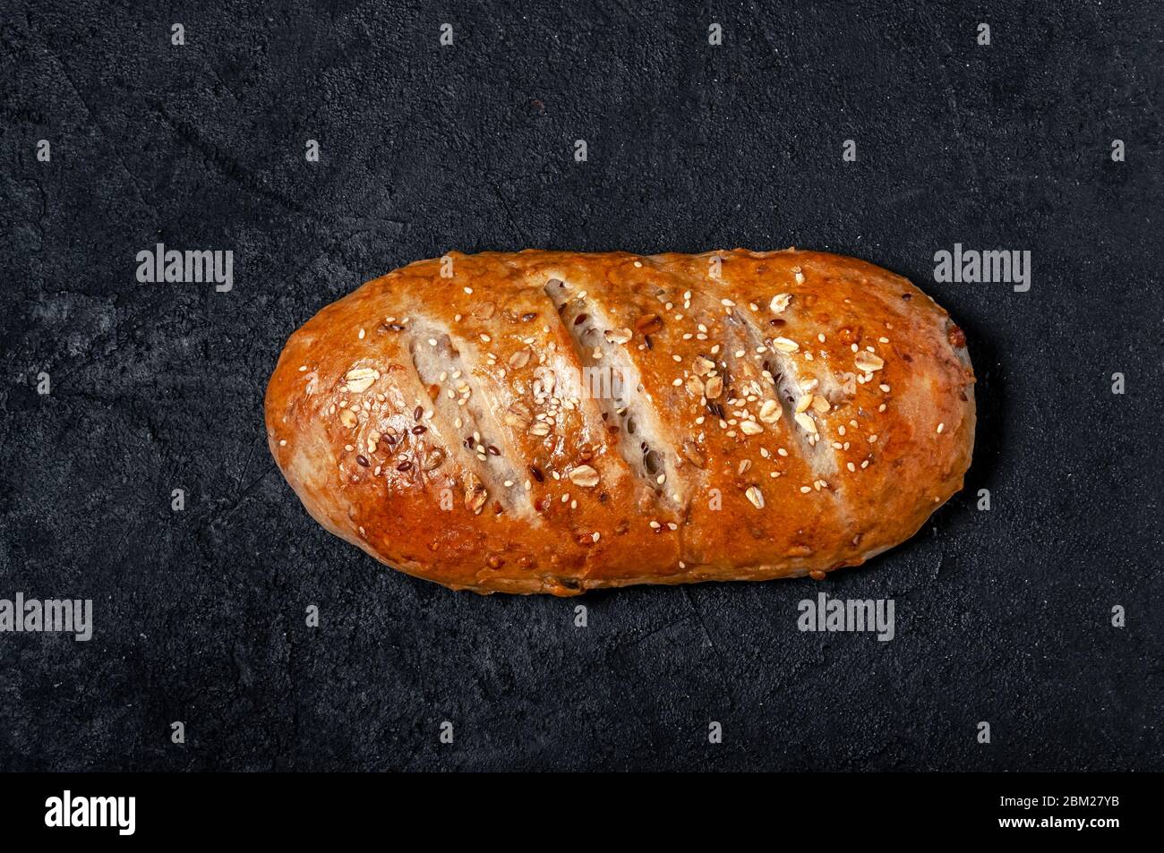 Homemade Wholemeal Multigrain Bread with Flax Seeds and Sesame on Dark Table. Top View Flat Lay. Copy Space Stock Photo