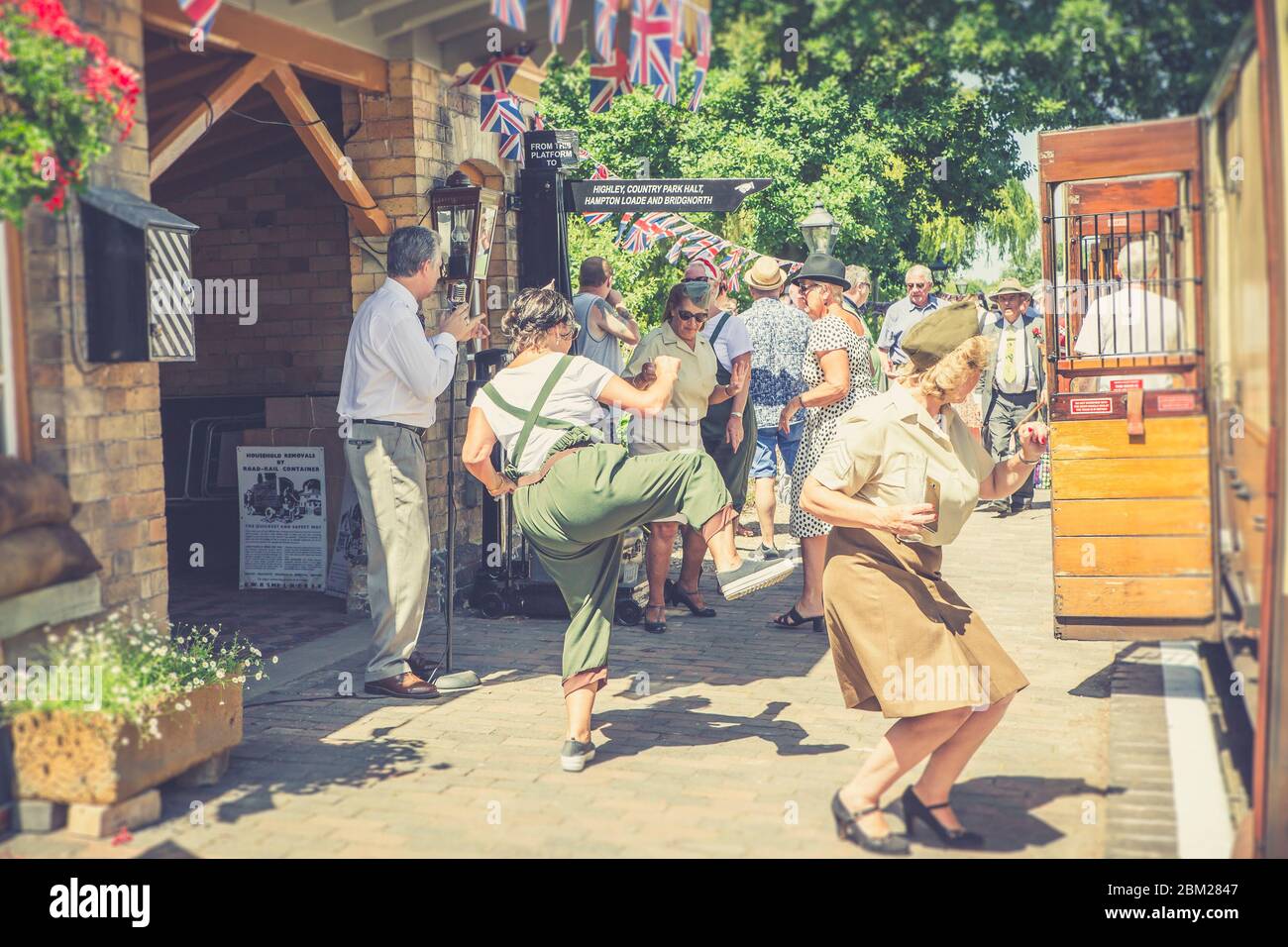 1940s WWII wartime Britain event, Severn Valley Railway, UK. People having fun dancing on vintage platform to live music in 1940s dress, costume. Stock Photo