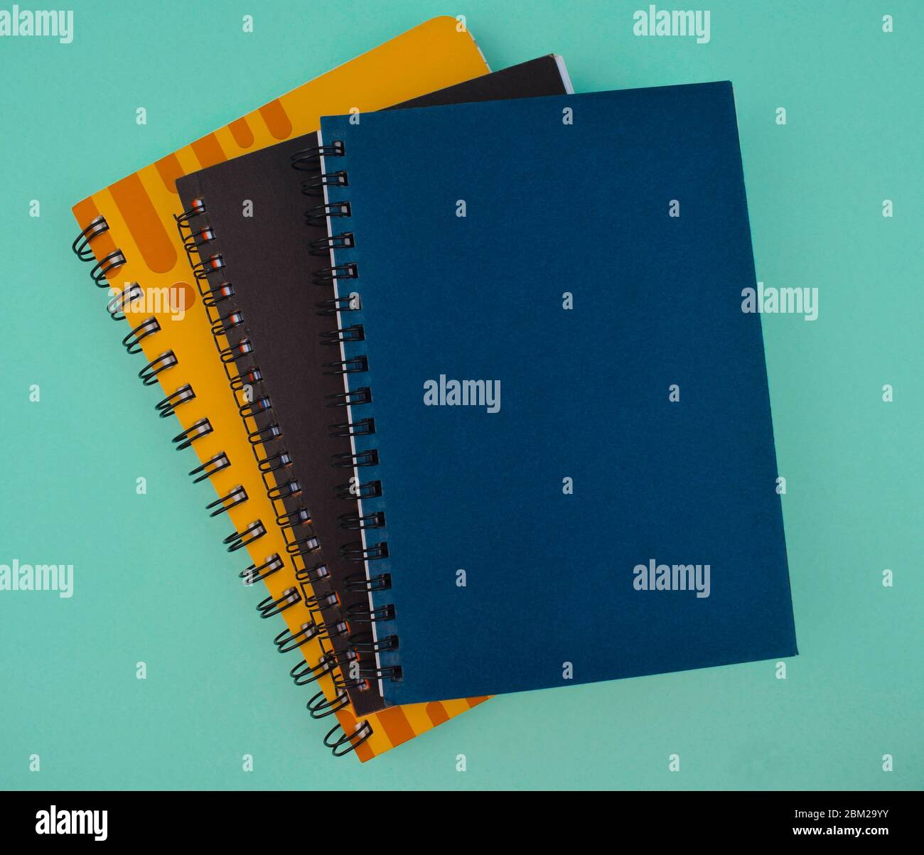 Some different colored paper diaries isolated on a light blue isolated paper background Stock Photo