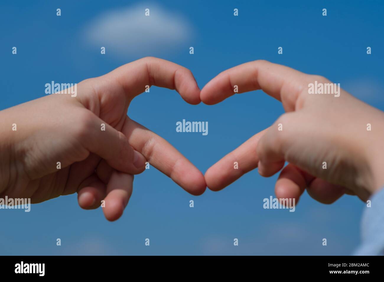 Love Concept Heart Shape Hand Gesture Little Girl Made A Heart With Her Fingers Against The Blue Sky Stock Photo Alamy