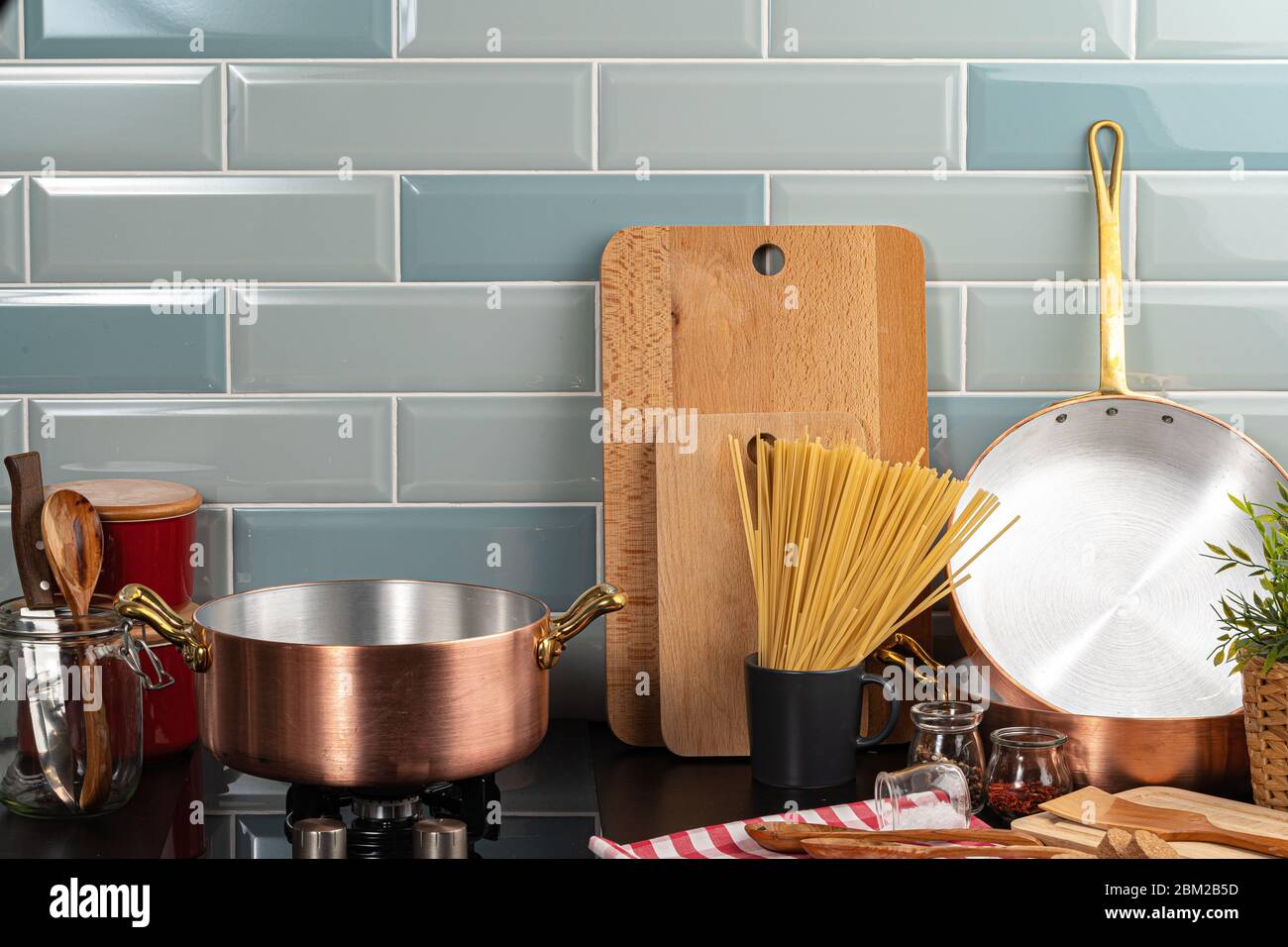 Dry spaghetti on a kitchen counter with cooking utensils Stock Photo