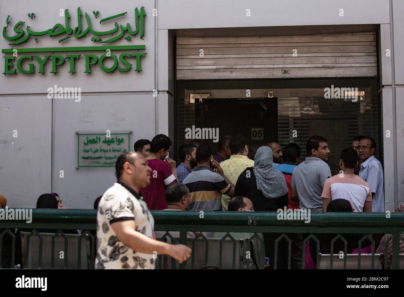 Cairo, Egypt. 06th May, 2020. People crowd outside a post office near the  popular street market of Al Ataba. Despite the rising fears of the  Coronavirus pandemic and the measures taken by