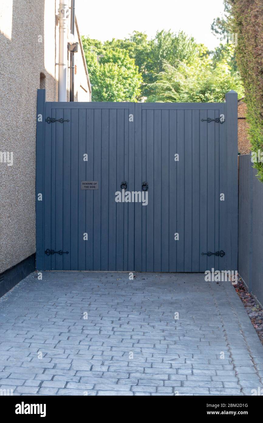 a close up view of a double door gate that is leading up to the drieway of  a house on the main street Stock Photo - Alamy