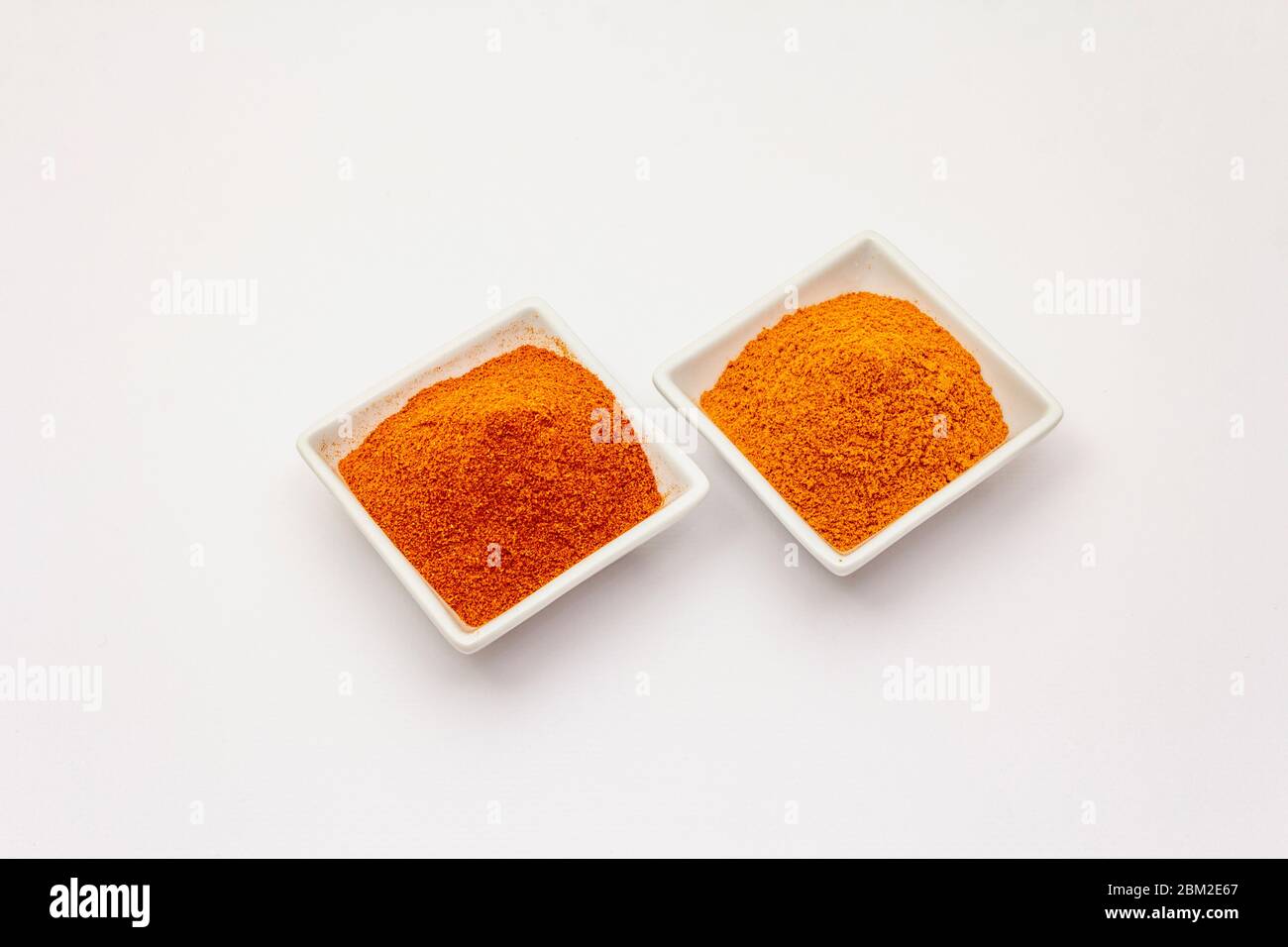 Two types of Hungarian paprika powder, hot and sweet, isolated on white