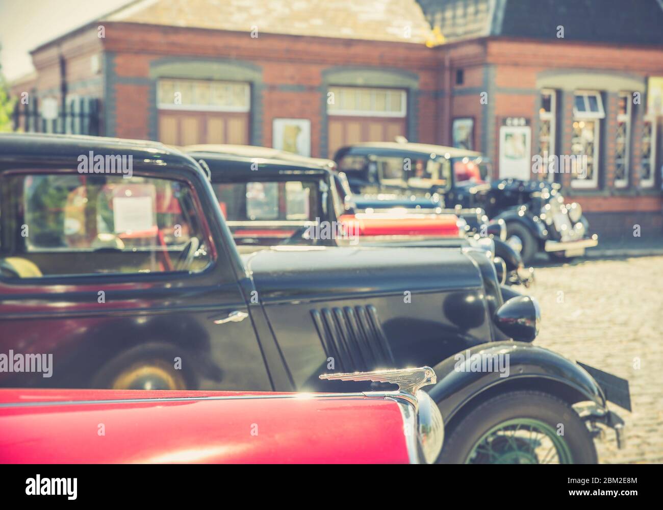 Retro view of vintage classic cars parked outside in sunshine, Severn