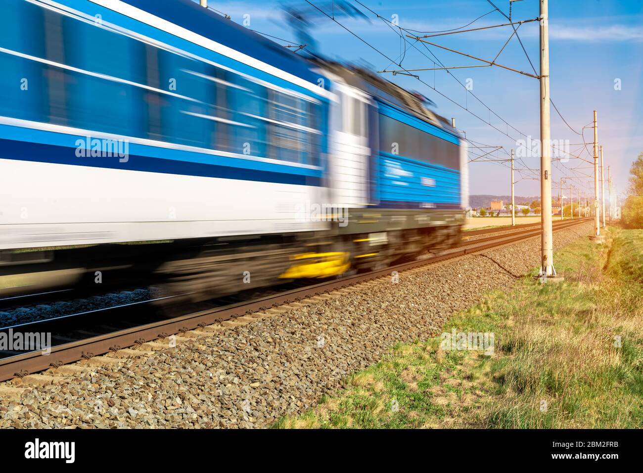 train going to a stop opposite the sun Stock Photo