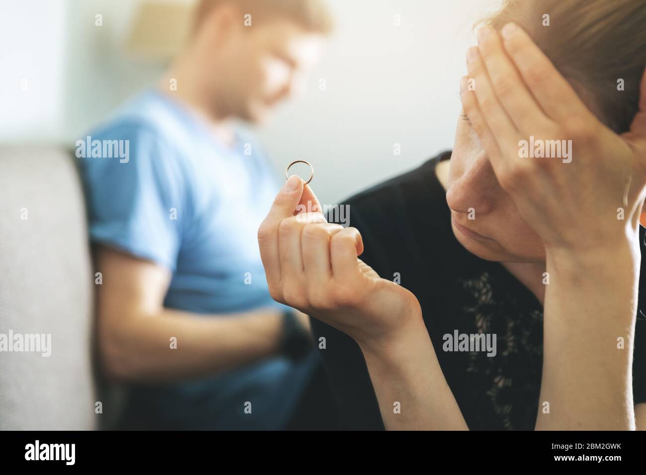 marriage problems and conflict concept - unhappy woman holding wedding ring and thinking about divorce Stock Photo