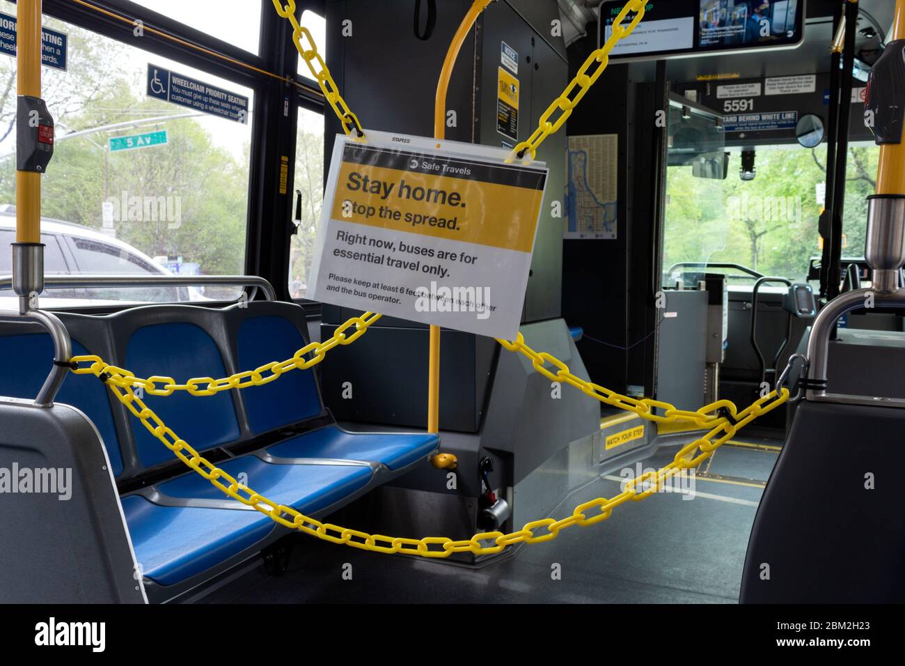 sign on a city bus urging social distance. Due to the coronavirus or covid-19 pandemic, front parts of buses are chained off to protect drivers Stock Photo