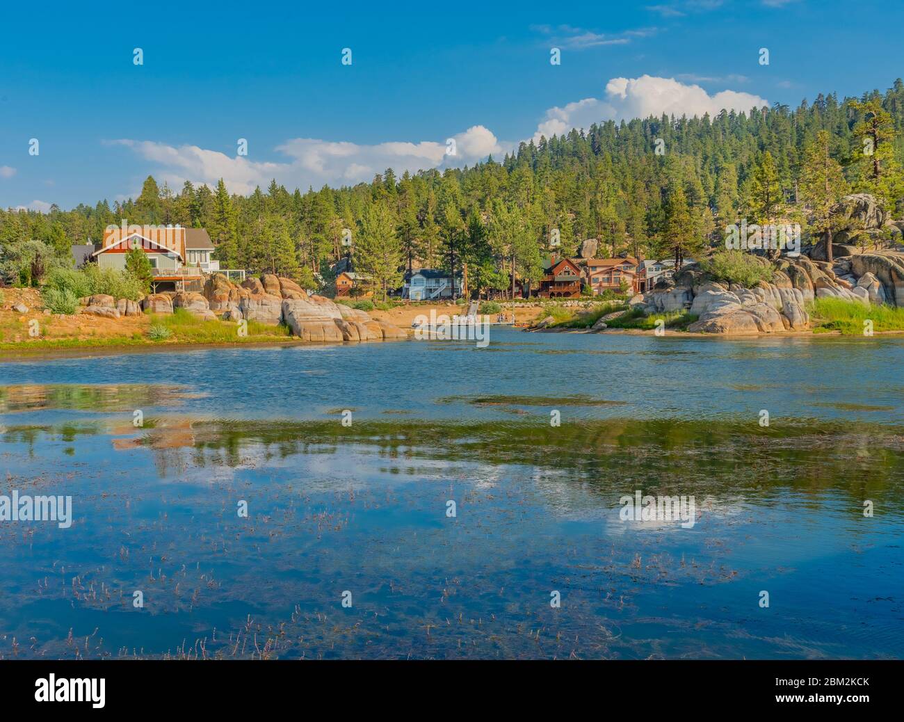Vacation homes line the back bay of Boulder Bay and reflect many colors into Big Bear Lake, California Stock Photo